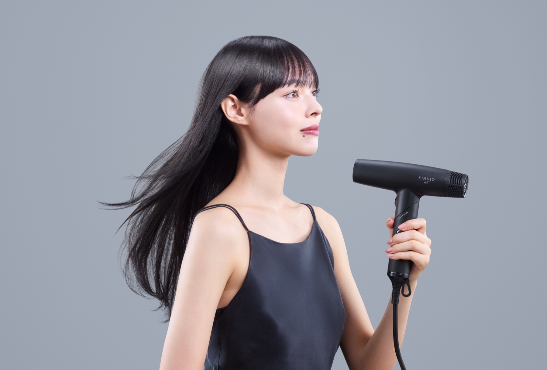 ドライヤーで髪を乾かす女性